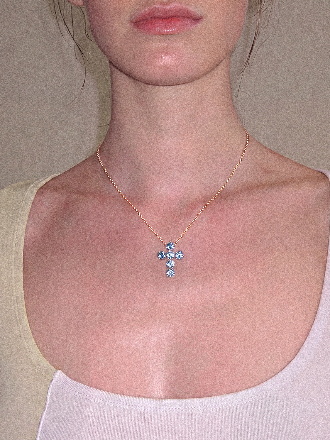 Model wearing the Bow Tie Lab Diamonds 1.55 ctw 7-stone Fancy Blue cross pendant necklace — round blue lab-grown diamonds on a delicate gold chain at the neckline.