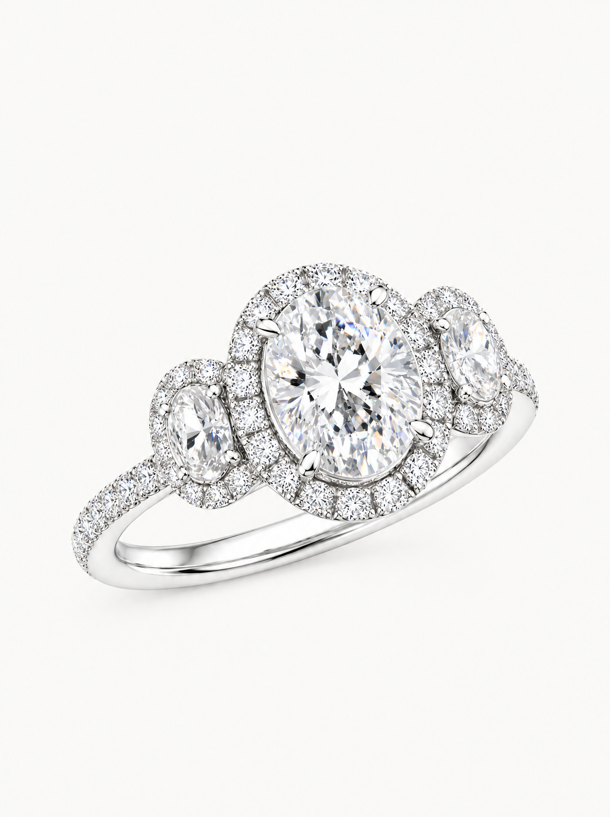 7.00 ctw Oval Three-Stone Halo Pave Lab-Grown Diamond Engagement Ring in 14K white gold, angled side view — Bow Tie Lab Diamonds